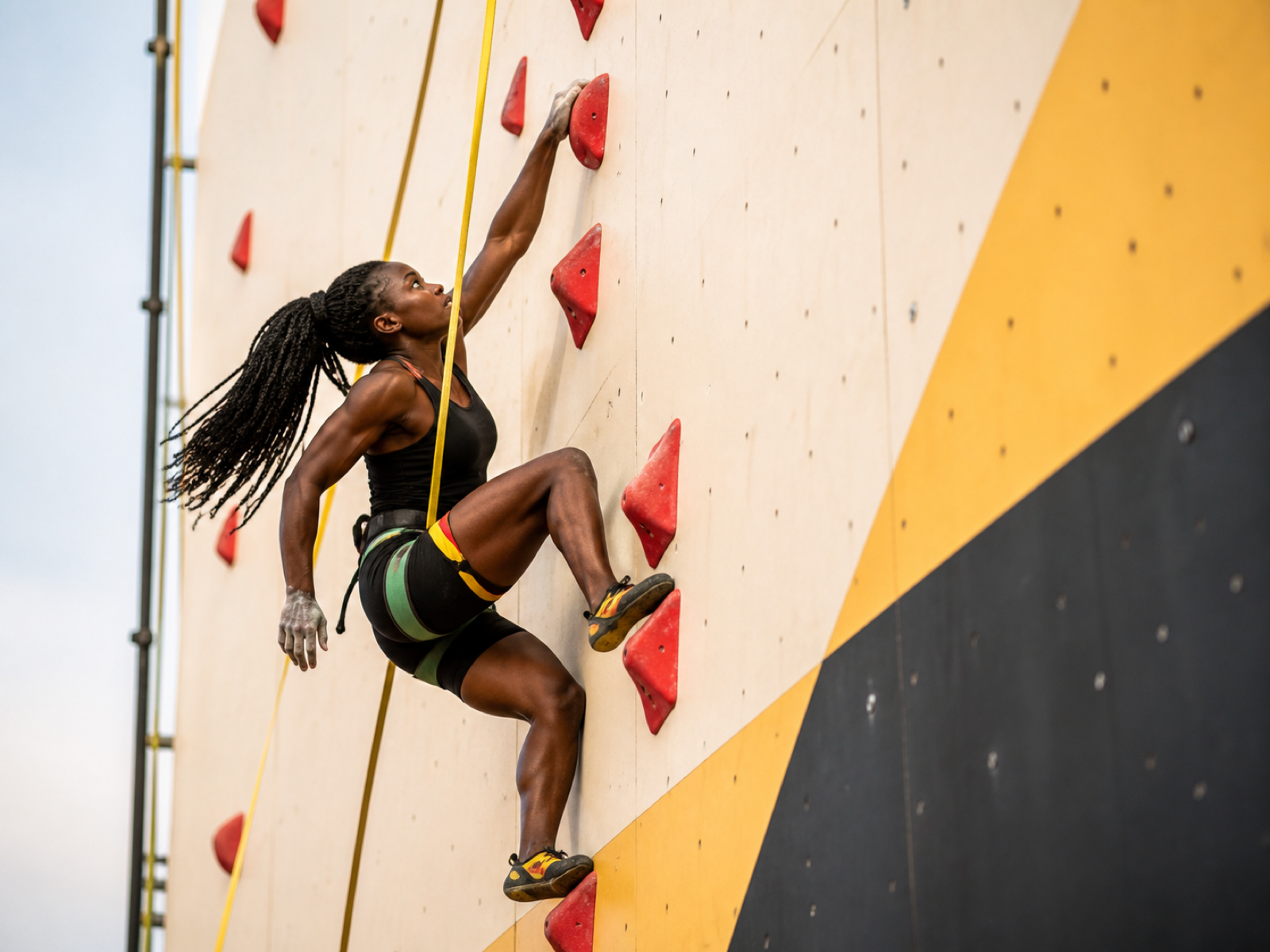 A Black speed climber racing up a standardised wall